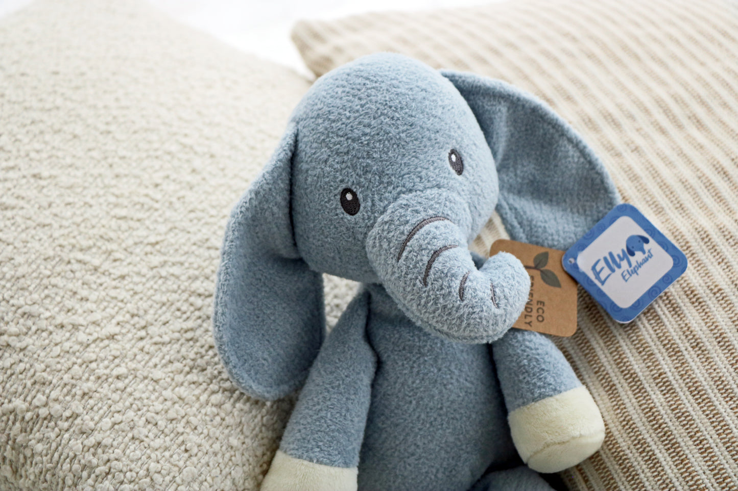 Elly Elephant Plush 14" on neutral cushions background. Newborn baby soft toy plush for babies close up.