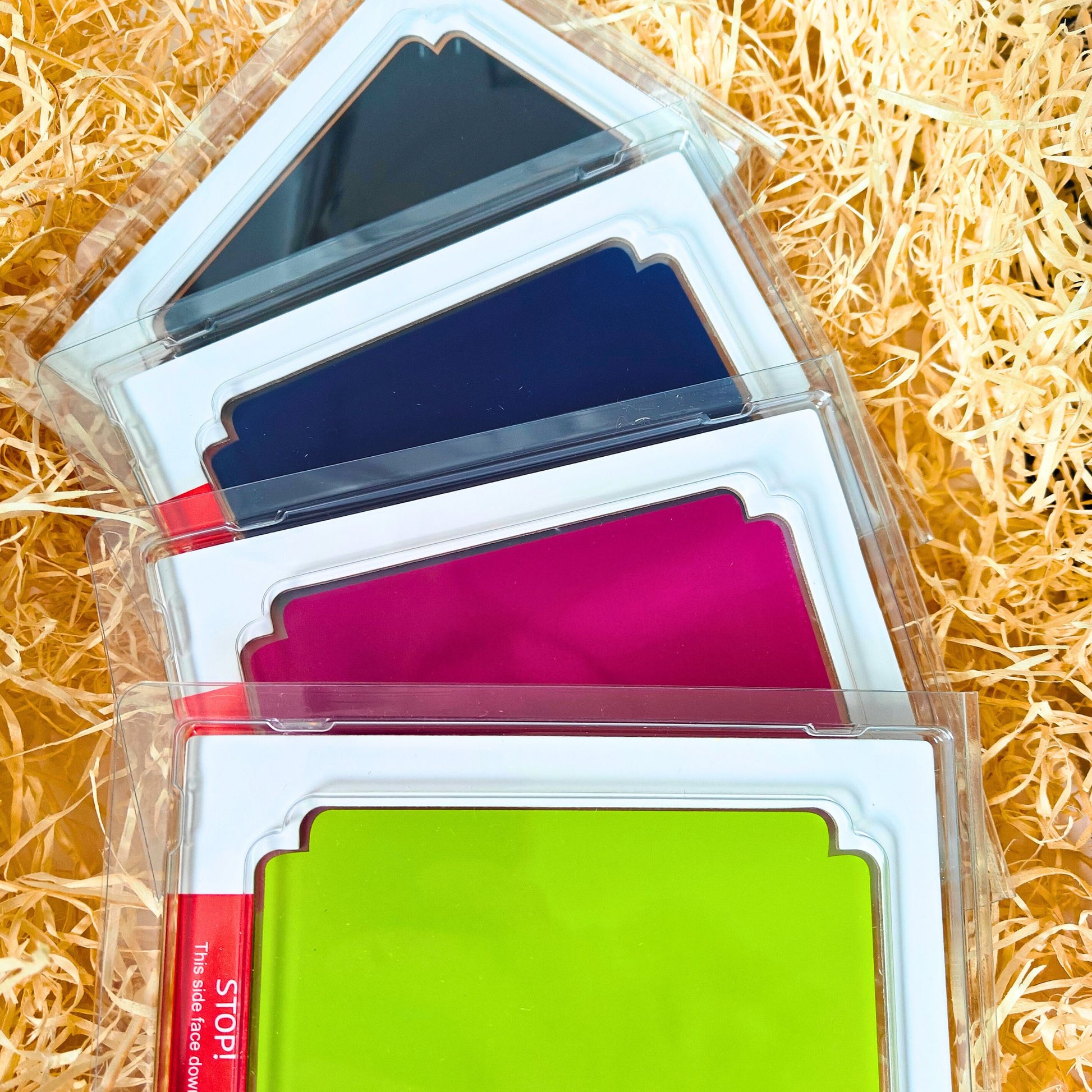 Set of 4 Clean Touch mess free ink pads - Black, Dark Blue, Light Green and Fuchsia for handprints and footprints. On a bed of straw