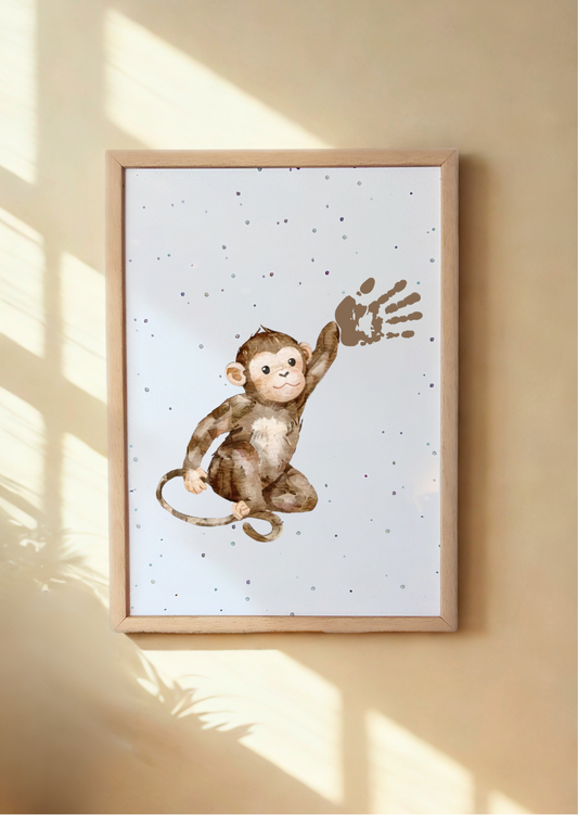 Framed artwork of a monkey on a white background with a wooden frame, hanging on a beige wall. Framed Monkey Handprint Keepsake Print with child's handprint as its hand