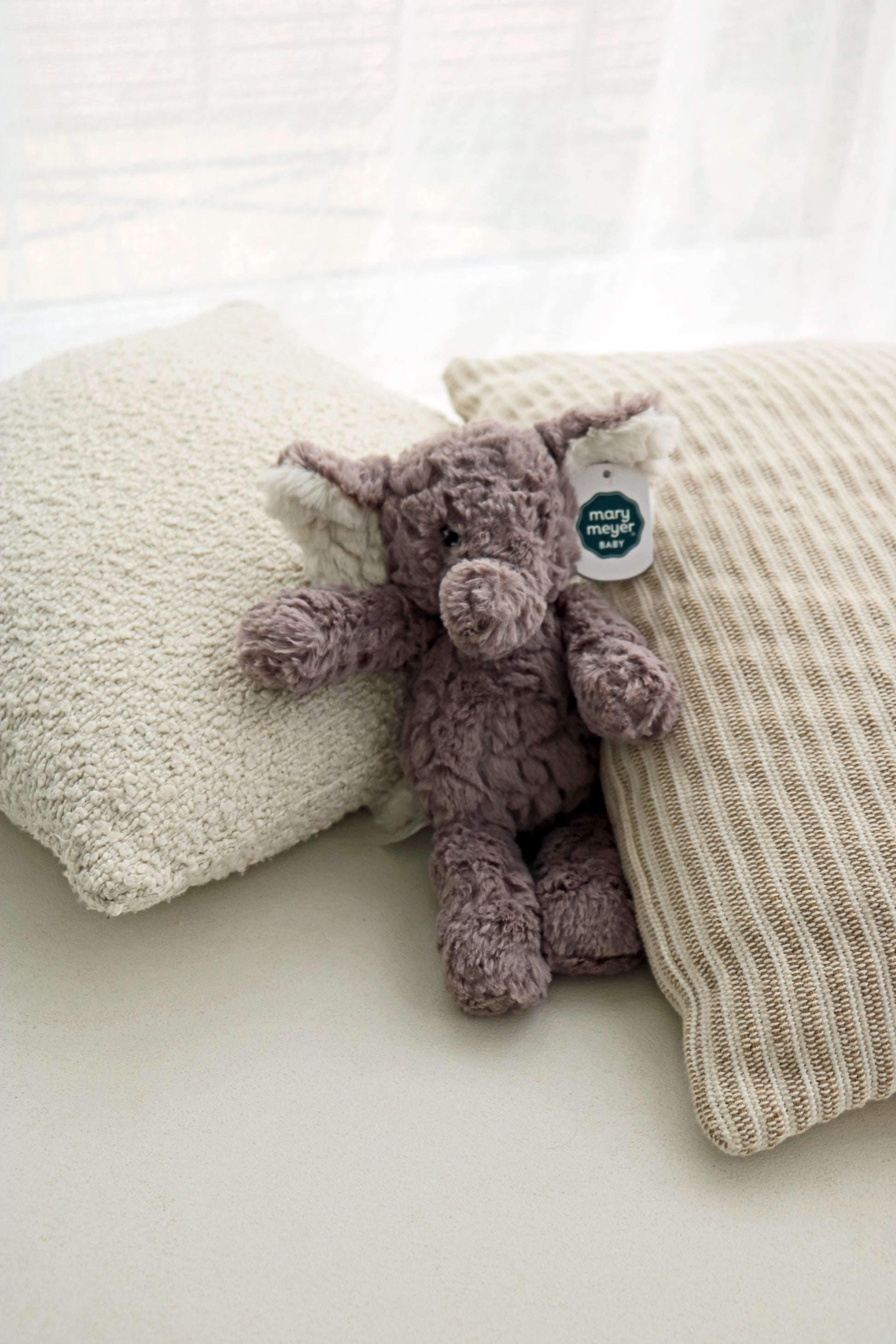 Mary Meyer Putty Elephant soft toy plush for babies and newborn on neutral cushions background