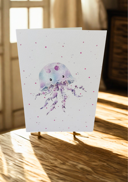 Greetings Card - Watercolour Jellyfish. Blank inside. On wooden table with warm sunlight.